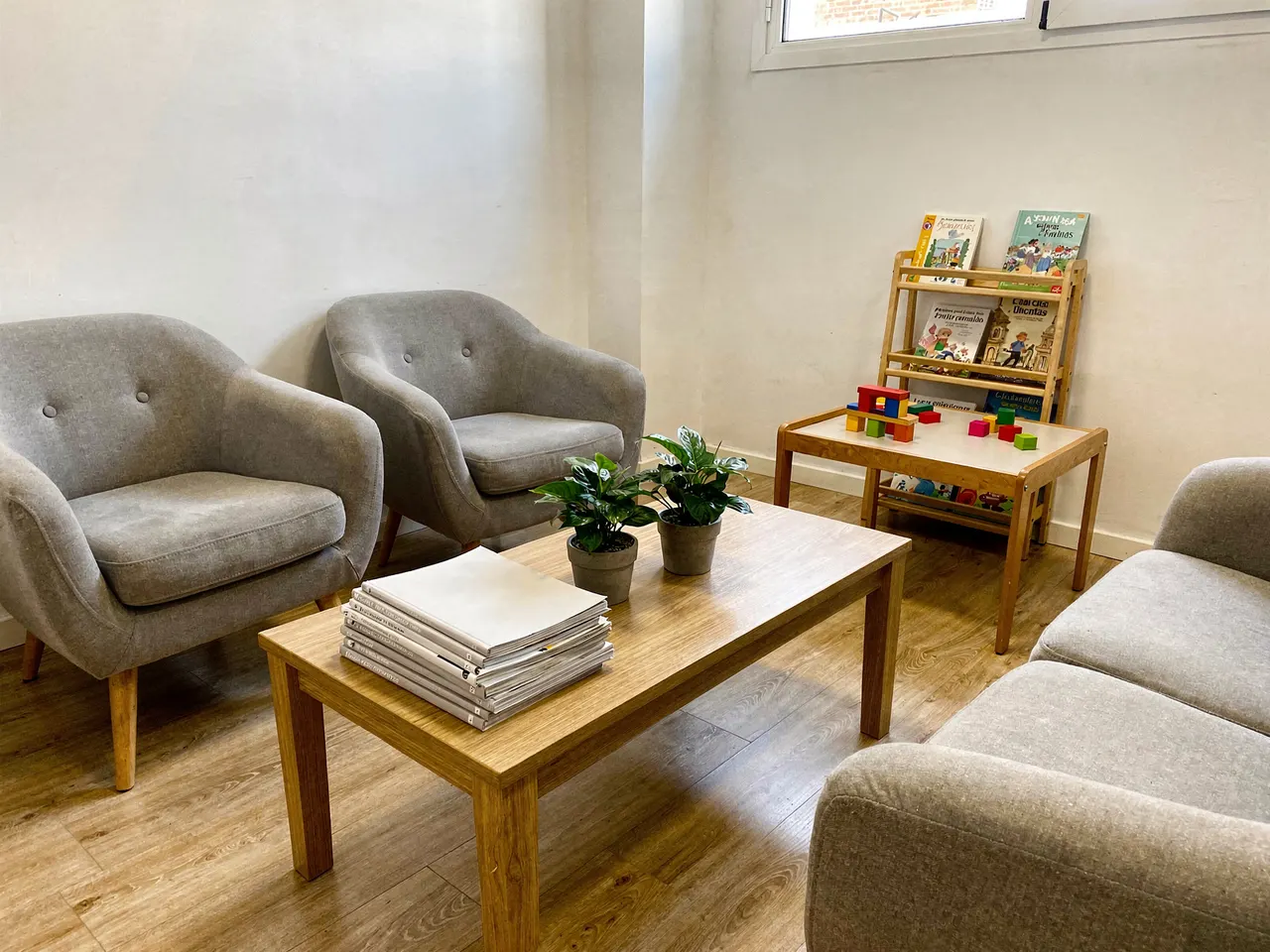 Sala de espera de la clínica con butacas y el rincón de los niños